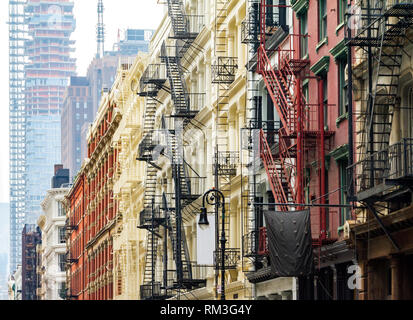 Vecchi edifici storici lungo Greene Street in Manhattan SoHo contrasto contro la torre moderna sullo sfondo dello skyline di Manhattan a New York City Foto Stock