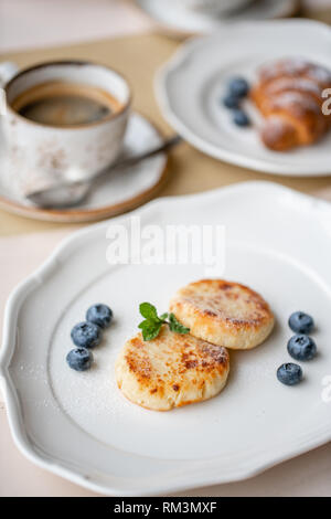 Cottage cheese frittelle o syrniki con mirtillo su piastra bianca, vista ingrandita. Russo, Ucraino cucina. Una sana colazione gustosa Foto Stock