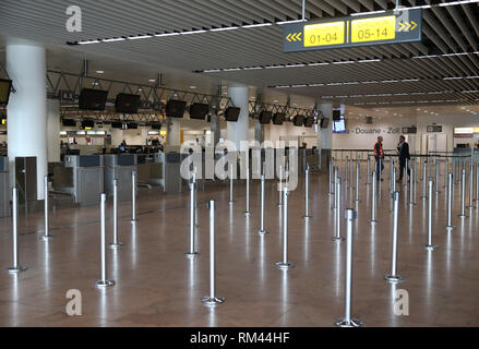 Bruxelles, Belgio. Xiii Febbraio, 2019. Due membri del personale di parlare di fronte a vuoto le scrivanie di imbarco presso la sala partenze durante uno sciopero dal belga sindacati all'aeroporto internazionale di Zaventem a Bruxelles, Belgio, Feb 13, 2019. Tutti i voli in e fuori del Belgio sono stati annullati per un giorno a causa di uno sciopero del paese del controllo del traffico aereo ha annunciato martedì. Credito: Voi Pingfan/Xinhua/Alamy Live News Foto Stock