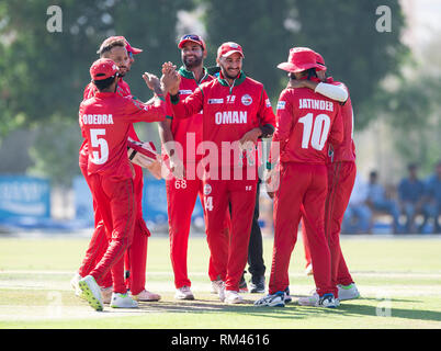 Muscat Oman. Xiii Febbraio, 2019. Pic mostra: Oman's Mehran Khan viene assaliti da compagni di squadra dopo la cattura di Irlanda capitano, Paolo Stirling, per 71 come Irlanda prendere su Oman il primo giorno dell'Oman serie quadrangolare. Credito: Ian Jacobs/Alamy Live News Foto Stock