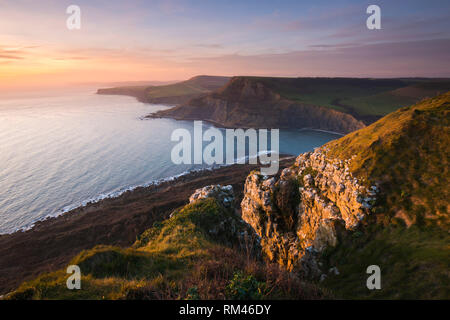 Worth Matravers Dorset, Regno Unito. Il 13 febbraio 2019. Regno Unito Meteo. Vista del tramonto dal South West Coast Path sulla collina Emmetts guardando verso a Chapmans Piscina vicino a Worth Matravers sul Dorset Jurassic Coast alla fine di una giornata di sole. Credito Foto: Graham Hunt/Alamy Live News Foto Stock