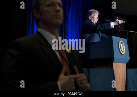 Washington DC, Stati Uniti d'America. 13 feb 2019. Il presidente statunitense Trump (R) è visto dietro a noi agente dei servizi segreti offrendo commento presso i principali degli sceriffi della contea e le città principali capi Associazione Conferenza congiunta, a Washington, DC, Stati Uniti d'America, 13 febbraio 2019. Leader repubblicani chiedono Trump a firmare una legislazione che assegna circa 1.375 miliardi di dollari (1.218 miliardi di euro) per oltre cinquanta chilometri di barriere fisiche lungo il confine. Credito: MediaPunch Inc/Alamy Live News Foto Stock