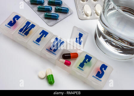 Scatola di pillole settimanali con i farmaci, immagine concettuale, composizione orizzontale Foto Stock