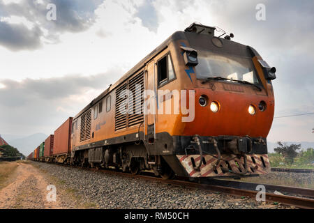 Cambogia, Kampot Provincia, Kampot, stazione ferroviaria, Cinesi costruirono locomotore BB1061 tirando treno merci che trasportano contenitori da Sihanoukhville a P Foto Stock