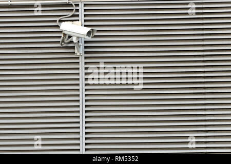 Videocamera di sicurezza in un moderno edificio orizzontale parete strisce Foto Stock