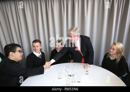 Il vice primo ministro irlandese un Tanaiste, Eamon Gilmore saluta gli studenti (da sinistra a destra) Ygor Ramos, Patryk Debowski, Keelan Murry e Caithlin O'Neill da San Patrizio, Belfast dopo una colazione di marcatura di discussione il quindicesimo anniversario della firma dell'Accordo di Belfast, lunedì 29 aprile nel Mac. Il Tánaiste ha aderito al Segretario di Stato per l'Irlanda del Nord Rt Hon Theresa Villiers MP all'evento che è stato imballato con i giovani nati nel 1998, i giovani e le organizzazioni comunitarie, i business leader e rappresentanti del mondo accademico. Foto/Paolo McErlane Foto Stock