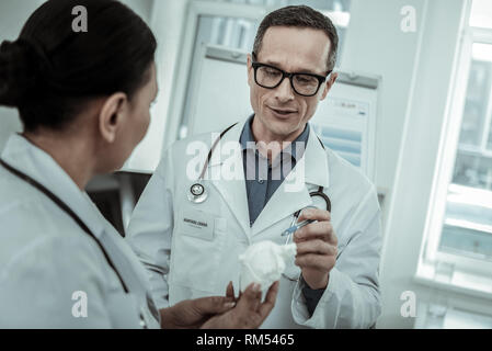 Medico maschio in vetri trasparenti puntando sul modello del cuore Foto Stock