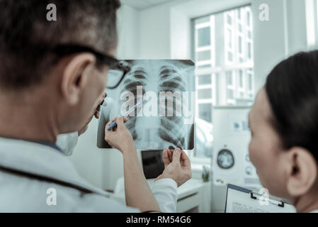Confuso medici attentamente guardando sulla struttura ossea Foto Stock