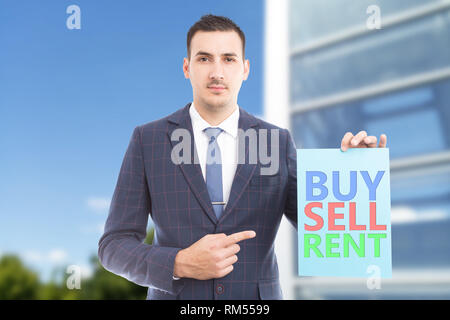 Agente immobiliare con cordiale di puntamento di espressione utilizzando il dito indice a comprare vendere affittare colorata carta blu segno Foto Stock