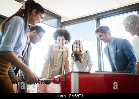 La gente di affari di grande tempo insieme.i colleghi tavolo da gioco calcio in ufficio. Foto Stock