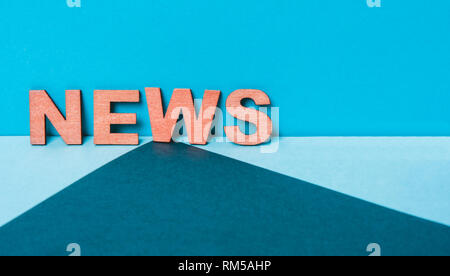 Parola notizie su un blu lettera in legno sfondo Foto Stock