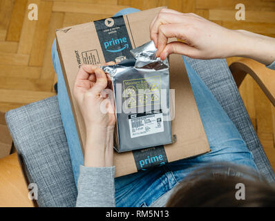 Parigi, Francia - Novembre 4, 2017: essa donna unboxing sul soggiorno poltrona la perfezione del Amazon scatola di cartone con Western Digital 6 terabyte HDD hard disk drive Foto Stock