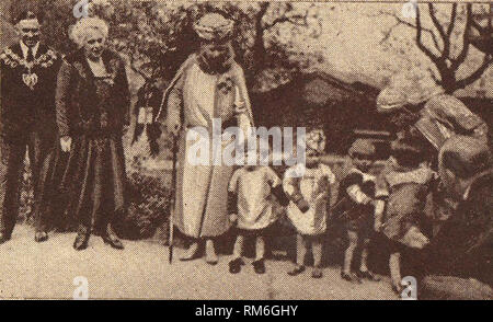 Circa 1939, una foto per la stampa raffigurante la regina Maria di Bretagna (Mary di Teck) -1867-1953 - La visita di un ospedale per bambini accompagnati da un sindaco locale e il sindaco di indossare le loro catene di office. Ella fu imperatrice di India e la moglie del re George V. Nel corso della sua vita fu anche la duchessa di York, duchessa di Cornovaglia e la Principessa di Galles Foto Stock