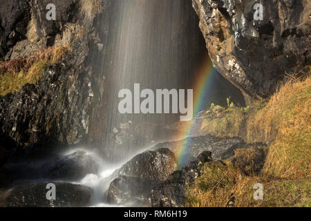 Close up di un arcobaleno in fondo Rubha Dubh cascata che si può raggiungere a piedi dietro sulle scogliere Carsaig, Isle of Mull, Scozia Foto Stock