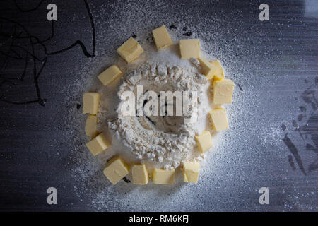 Il burro fette intorno della farina per impastare a bakerz Foto Stock