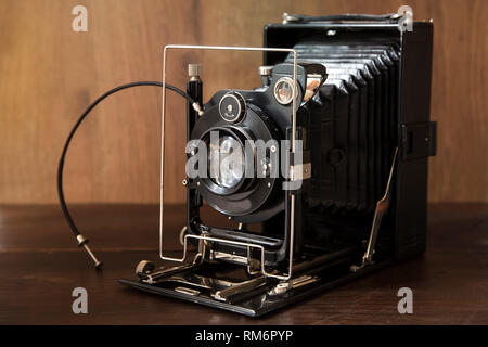 Vecchia macchina fotografica su sfondo di legno Foto Stock