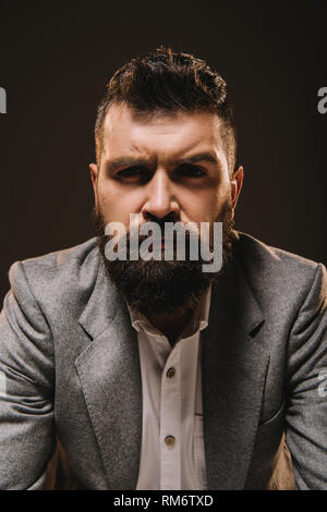 Bello barba imprenditore nel formale isolato di usura su marrone Foto Stock