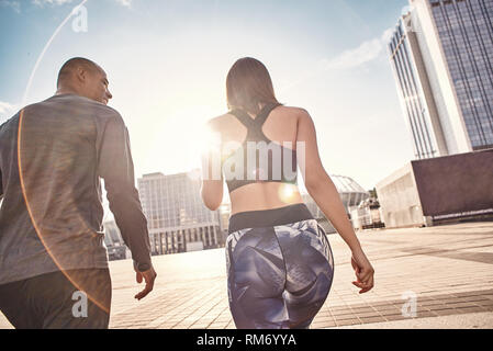 Che è stato ottimo allenamento vista posteriore della giovane coppia e multirazziale in abiti di fitness per andare a casa dopo la formazione del mattino insieme. Comune hobby. Un sano giovane. Sport concetto di motivazione. Concetto di fitness. Donne bellezza. La vita sana. Esercitare insieme. Attività di mattina. Foto Stock