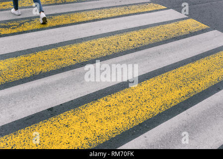 Crosswalk. Il bianco e il giallo delle linee. Strada asfaltata. La sicurezza della città. Foto Stock