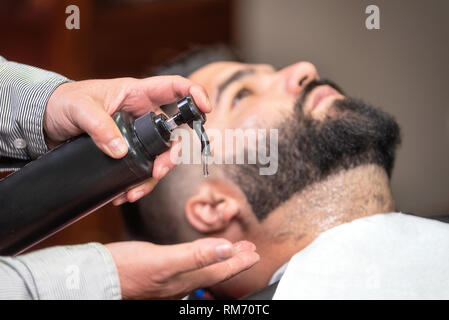Hair stylist applicare dopo la lozione di rasatura a Barber shop . Foto Stock