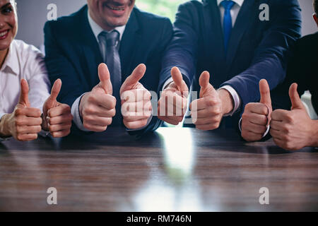 Imprenditori azienda big pollice in alto in una riga Foto Stock