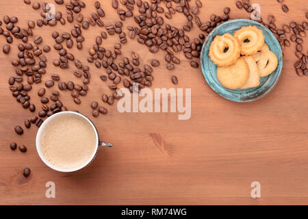 Un caffè in una tazza vintage, girato dalla parte superiore con i chicchi di caffè e il burro danese cookies con spazio di copia Foto Stock