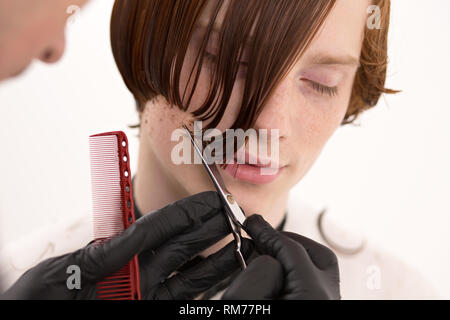 Vista dettagliata del il volto dell'uomo quando i suoi capelli rossi viene tagliato Foto Stock