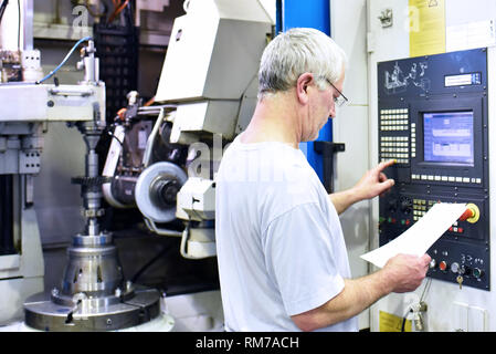 Macchina CNC in industriale moderna ingegneria meccanica - lavoratori sul luogo di lavoro Foto Stock