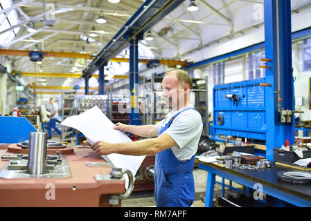 Lavoratore anziano in ingegneria meccanica - fabbrica industriale per la produzione di scatole ingranaggi in acciaio Foto Stock
