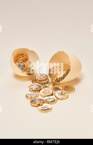 Uovo di nido con luccicanti monete cancelletto Foto Stock