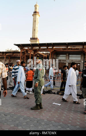 Un funzionario di polizia al controllo della folla che frequentano le preghiere in una moschea locale a Dubai negli Emirati Arabi Uniti (EAU) . Foto Stock