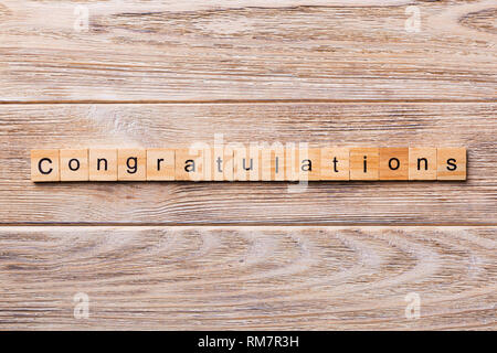 Congratulazioni parola scritta sul blocco di legno. Congratulazioni testo sul tavolo in legno per il desing, concetto. Foto Stock