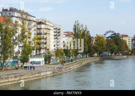 Le persone che si godono la soleggiata clima autunnale presso la banca di Donaukanal (Canale del Danubio) a Vienna, in Austria Foto Stock