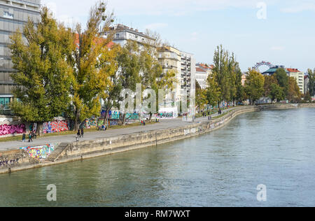 Le persone che si godono la soleggiata clima autunnale presso la banca di Donaukanal (Canale del Danubio) a Vienna, in Austria Foto Stock