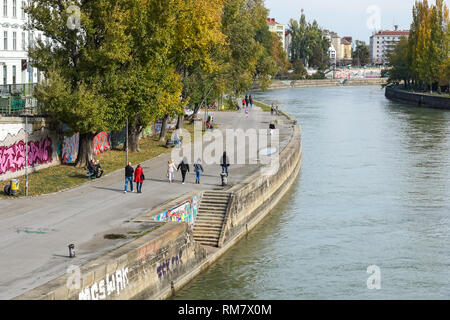 Le persone che si godono la soleggiata clima autunnale presso la banca di Donaukanal (Canale del Danubio) a Vienna, in Austria Foto Stock