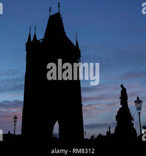 Torre nera dopo il tramonto con cielo rosso statua e lanterne. Foto Stock