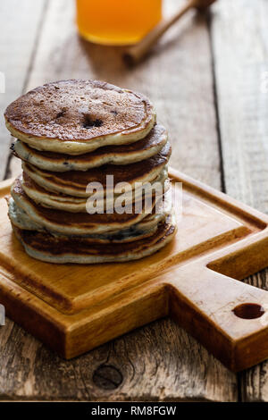 Pila di mirtillo pancake, una sana prima colazione al mattino sul tavolo di legno vicino, stile rustico Foto Stock