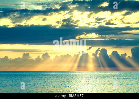 Paesaggio marino con un tramonto Cielo di sera con le nuvole e sole oltre oceano. raggi di sole risplendere rompere attraverso le nuvole Foto Stock