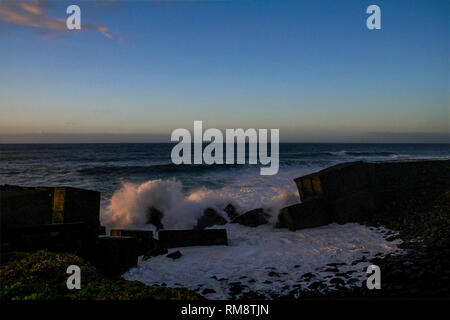 Forme d'onda colpendo la costa di Tenerife al crepuscolo, Isole Canarie Foto Stock