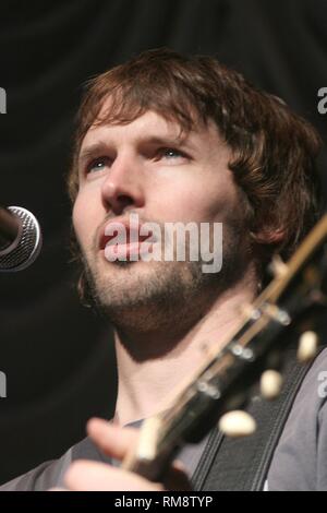 Musicista James Blunt è mostrato suonando una chitarra acustica durante un concerto da solista di prestazioni. Foto Stock