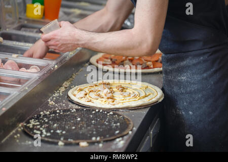 Baker ha stabilito che la carne di pollo sulla base di pizza diffusione da maionese Foto Stock
