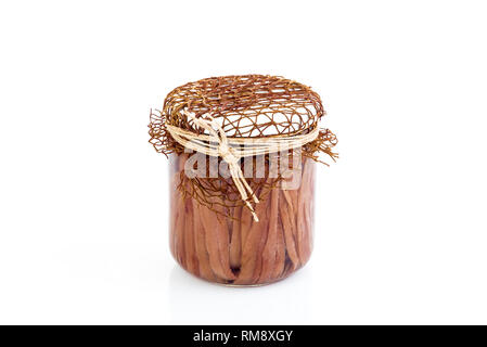 Filetti di Acciuga in olio di oliva in modo trasparente il vasetto di vetro. Il vaso pieno di salato di filetti di acciughe isolati su sfondo bianco, vicino. Foto Stock