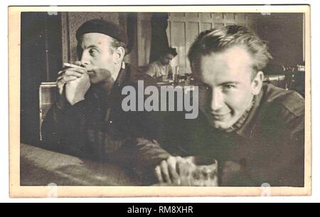 La foto retrò mostra l'uomo seduto nel pub. Gli ospiti del Czech inn. Fotografia in bianco e nero. 1960s Foto Stock