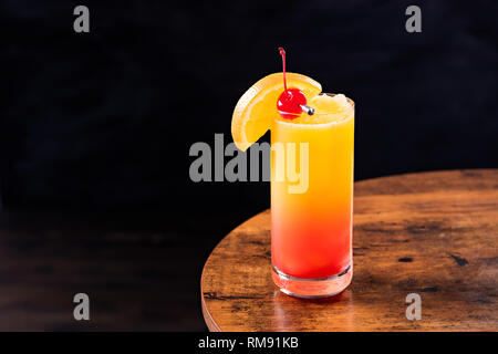 Aggiornamento Tequila Sunrise Cocktail su un tavolo Foto Stock