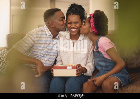 Felice americano africano padre e figlia kissing madre sulle guance Foto Stock