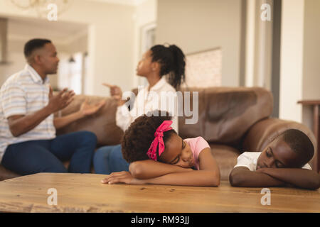 African American bambini appoggiata sul tavolo mentre i genitori sostenendo sul divano Foto Stock