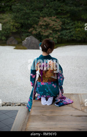 Geisha sul Padiglione Verandah, Donna vestita in kimono tradizionale esterno padiglione inginocchiato dal giardino di roccia giapponese, Karesansui in giapponese, Kenni Foto Stock