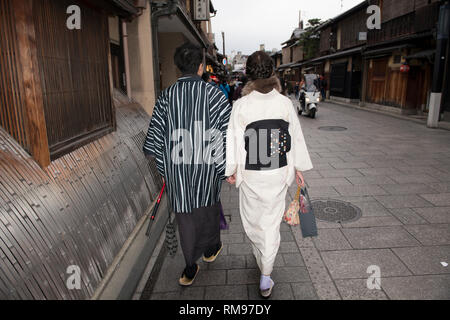 Coppia giapponese, indossando vestiti tradizionali camminando per strada, quartiere di Gion, Kyoto, Giappone Foto Stock