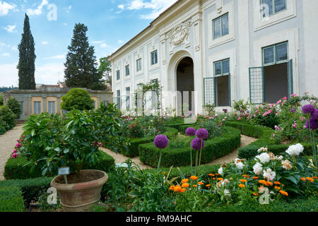 La Limonaia edificio circondato da fiori e piante presso il Giardino di Boboli di Firenze, Italia. Un Citrus sinensis è sulla sinistra in primo piano. Foto Stock