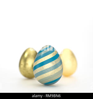 Tre uova di Pasqua il concetto di arte con nero rigato golden decorazione in close-up contro uno sfondo grigio con spazio di copia Foto Stock